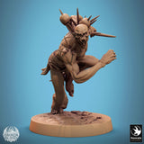 Action shot of a Ghoul Savage monster miniature with multiple skulls on its back in a running stance