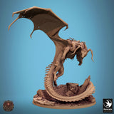 A detailed resin miniature of a black dragon in a dynamic landing pose on a rocky terrain base.