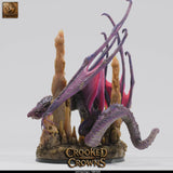 Deep dragon miniature shown from the left side, with its head lowered and tail curving around the terrain base.