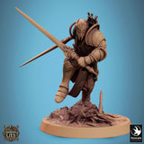 Eine maskierte Elfenkrieger-Miniatur mit einem langen Speer, aufrecht stehend in verzierter Rüstung auf Felsboden.