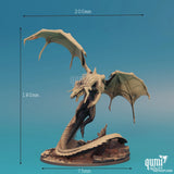 A black dragon miniature shown against a blue background with height, width, and base dimensions labeled.