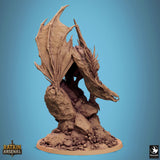 Seitenansicht einer geflügelten Drachenminiatur, die auf einem mit Totenköpfen und Knochen bedeckten Felsen thront.