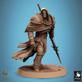 Hooded fighter miniature in heavy armor, dynamic pose holding a spear, back view of the tattered cloak.