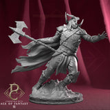 A 3D-printed resin axe fighter miniature standing on a detailed rocky base with his arm outstretched.