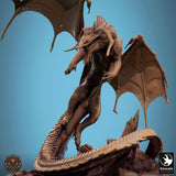 Low angle view of the dragon miniature roaring with open mouth, wings spread, and tail coiled around a rock base.