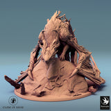 Angled front view of the assembled Briar Dragon miniature perched on a rocky base.