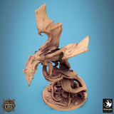 High-angle view of a resin dragon miniature perched on a twisted tree root base with spread wings.