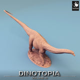 High-angle view of a resin Diplodocus miniature showing its long tail and dinosaur body texture.