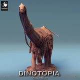 Full front view of the Diplodocus wearing decorative armor and carrying a massive cargo structure.