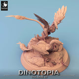 Angled aerial view of the Microraptor dinosaur miniature duo set on a textured scenic base.