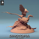 Side profile of two Microraptor miniatures showing detailed feather textures on the rocky outcrop.