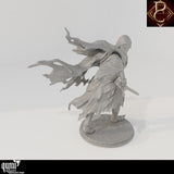 Back view of a hooded warrior miniature in ragged robes holding a dagger on a round base.
