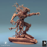 Tree monster miniature, sitting pose on rocks, holding magical energy in hand.