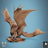 Back view of a detailed bronze dragon miniature featuring large wings and a long tail on a circular base.