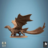 Side profile of a 3D-printed bronze dragon miniature standing on a flat base with wings spread