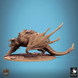 Side view of the wyvern miniature in a dynamic, low-crouching pose on a textured ground base.
