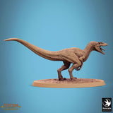 Side view of a running raptor miniature on an oval base.